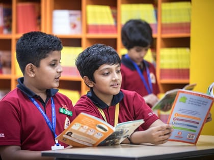 Two boys reading books in a school library